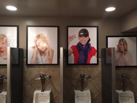 Pictures above the urinals at a bar.